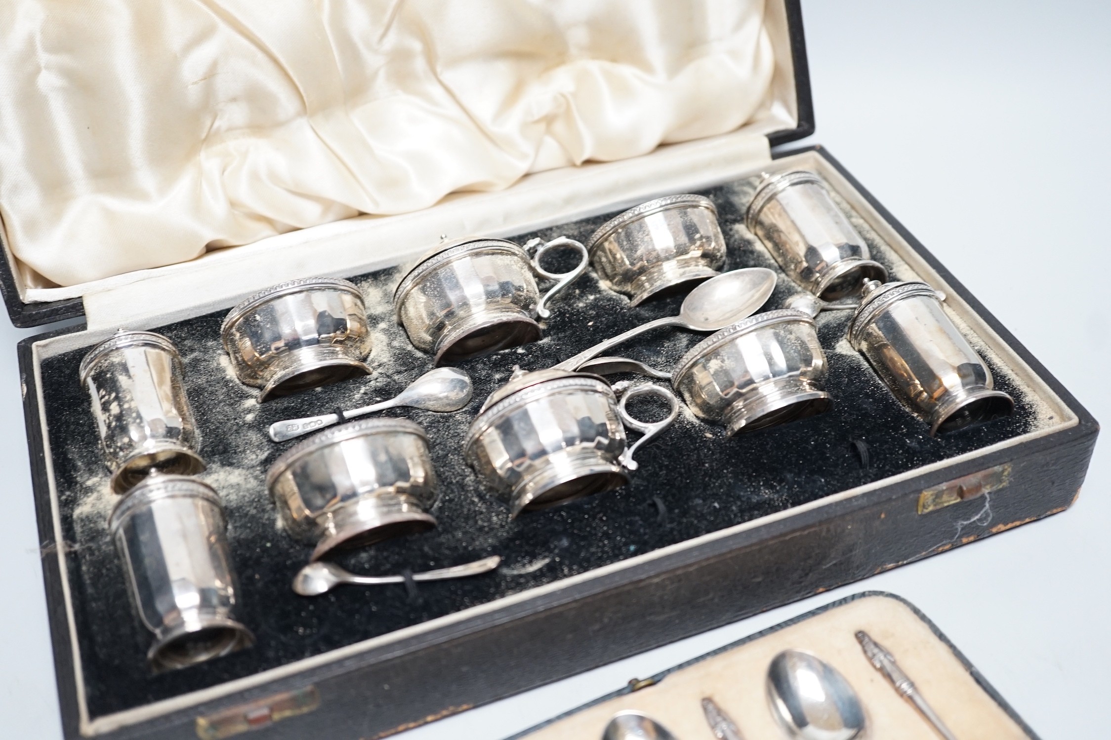 A cased George V ten piece silver condiment set, with four (ex 6) spoons, maker, RR, Birmingham, 1936 and London, 1929, together with a cased set of six silver teaspoons.